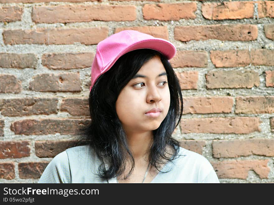 Pretentious asian girl over brick wall. Pretentious asian girl over brick wall