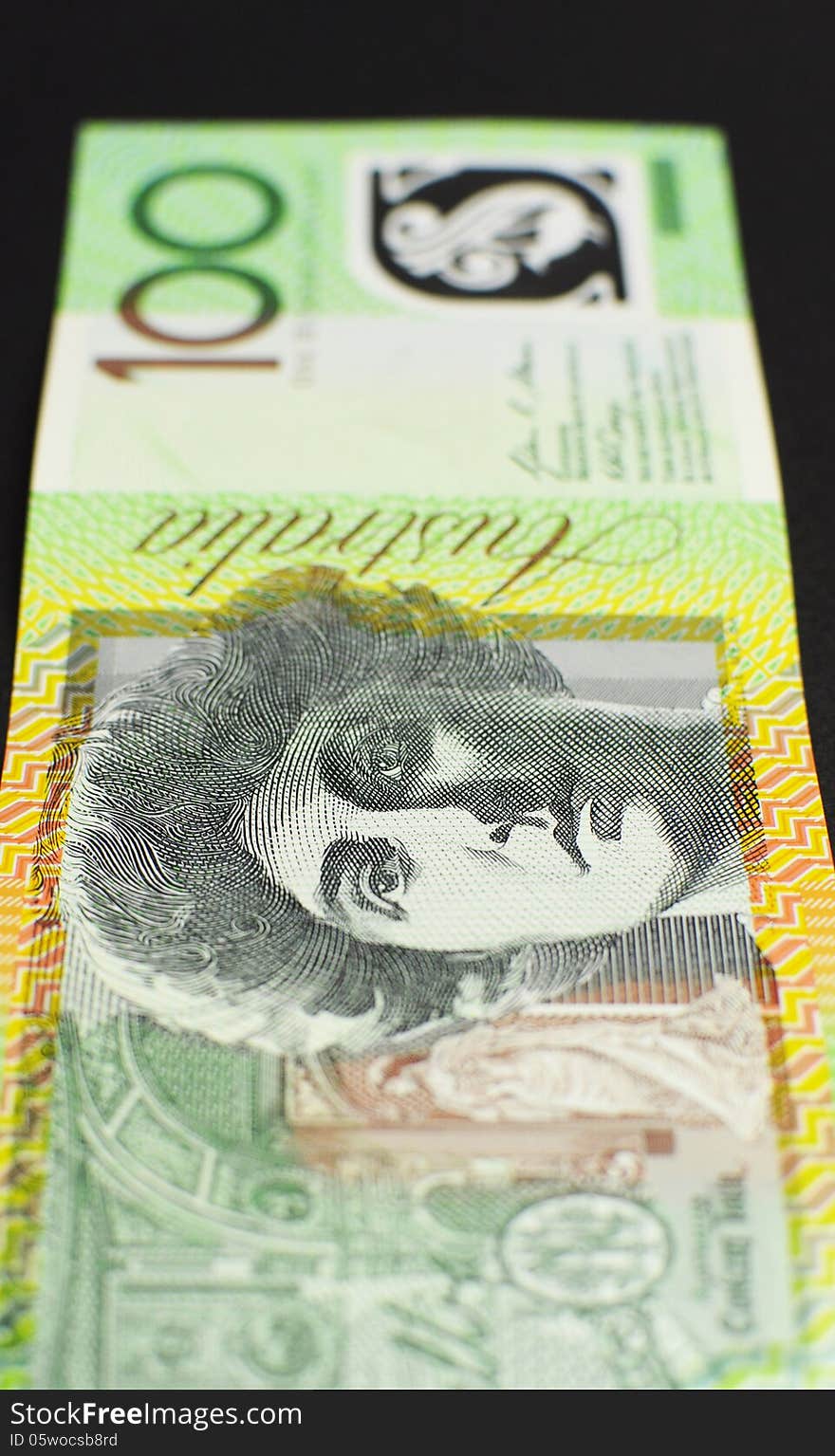 Australian green and gold 100 hundred dollar note, against a black background. vertical. Australian green and gold 100 hundred dollar note, against a black background. vertical.