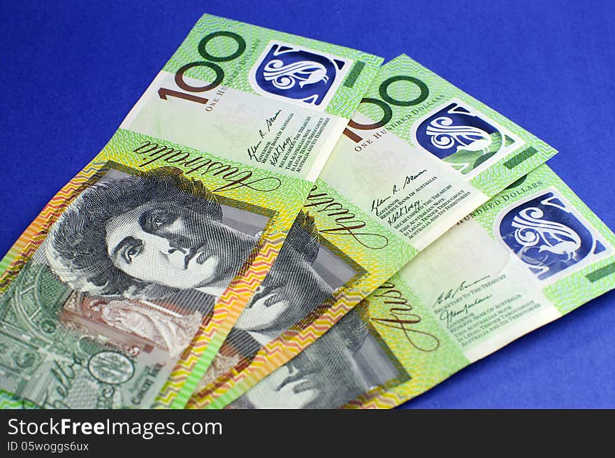 Three hundred Australian green and yellow notes on blue background. Three hundred Australian green and yellow notes on blue background.