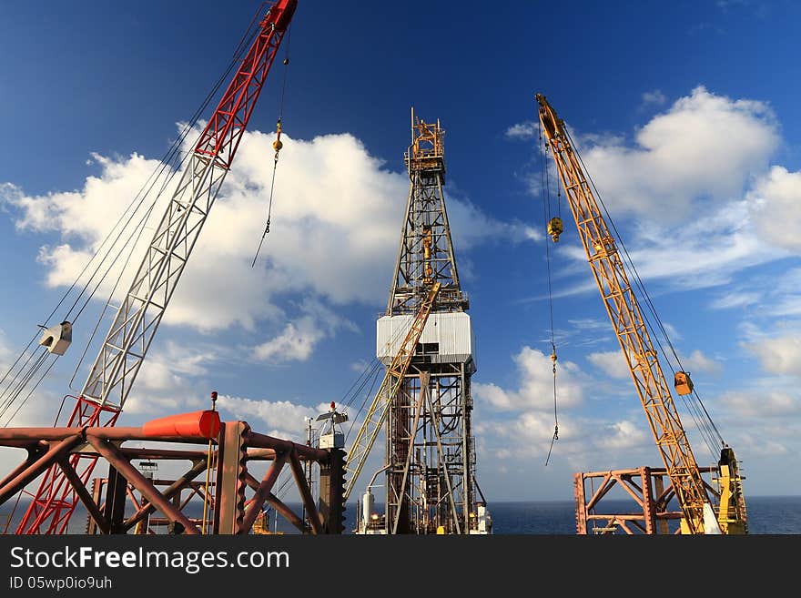 Jack Up Offshore Drilling Rig With Rig Cranes on Sunny Day in The Middle of Ocean