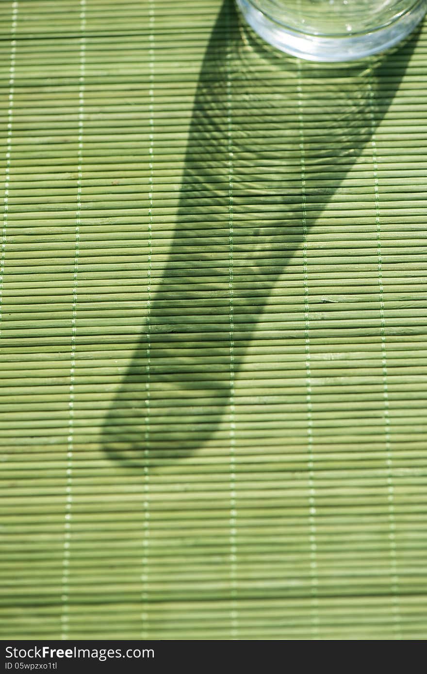 Shadow from a vase on a green background in a sunny day. Shadow from a vase on a green background in a sunny day