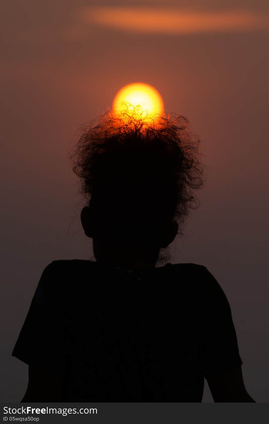 Silhouette of a man with golden sun rise on his afro hair style