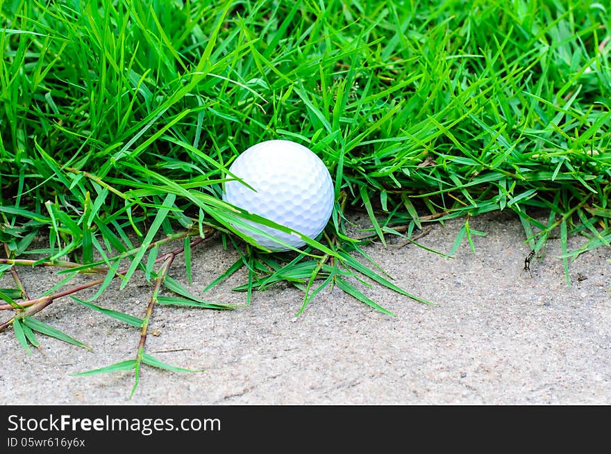 Golf ball out off fairway on cement a road