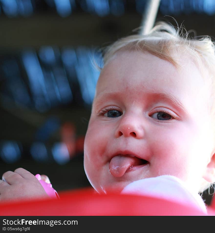 Blonde blue eyed baby girl with tongue out. Blonde blue eyed baby girl with tongue out