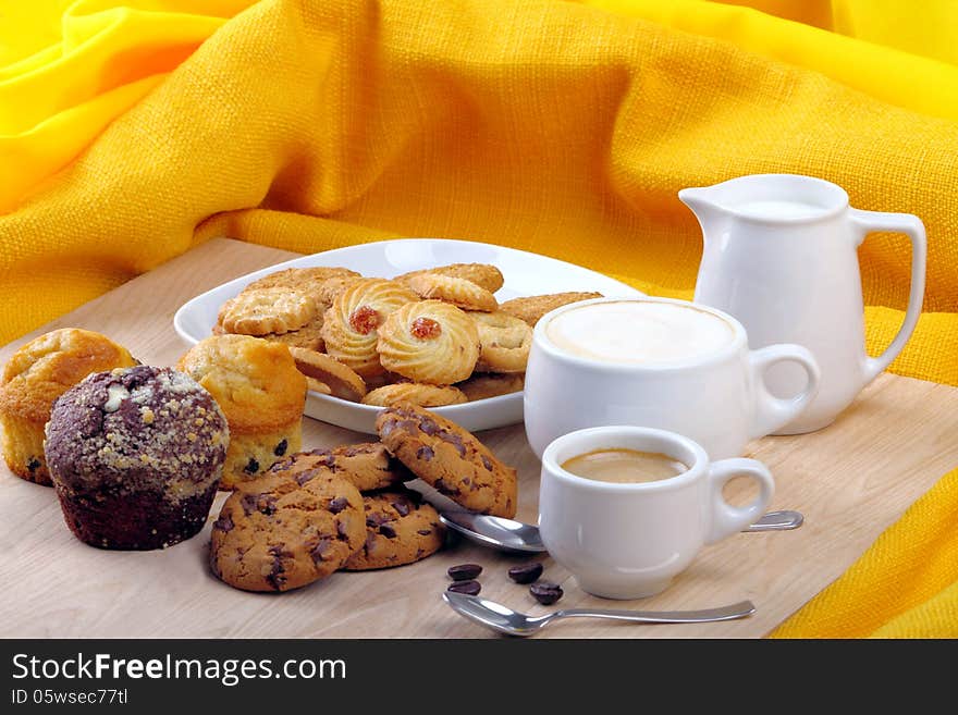 Breakfast with muffins, cookies and milk and coffee