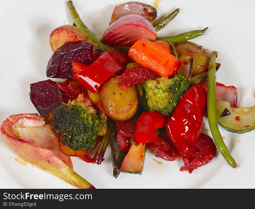 A closeup image of a white dinner plate with with different healthy vegetables. there are mushroom gravy, potatoes, red pepper, carrots, red beet, fennel, onions, green beans,zucchini, broccoli and a garnish. A closeup image of a white dinner plate with with different healthy vegetables. there are mushroom gravy, potatoes, red pepper, carrots, red beet, fennel, onions, green beans,zucchini, broccoli and a garnish.