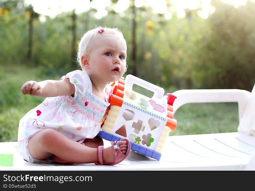 Blonde blue eyed baby girl with a toy. Blonde blue eyed baby girl with a toy