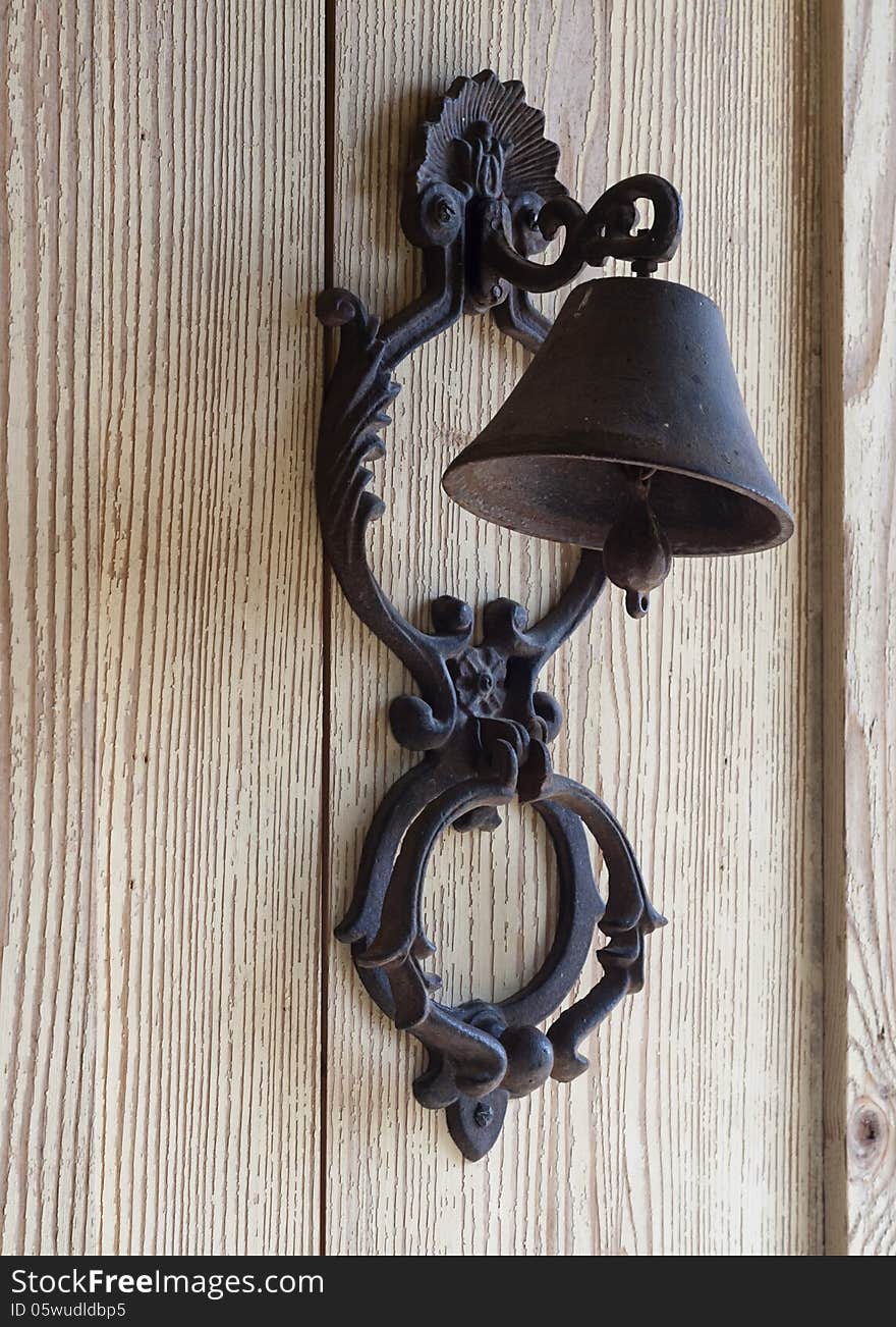 Iron bell hanging on a wooden wall