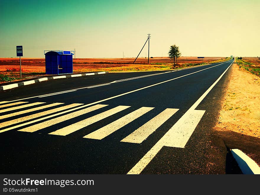 Bus stop and long empty road