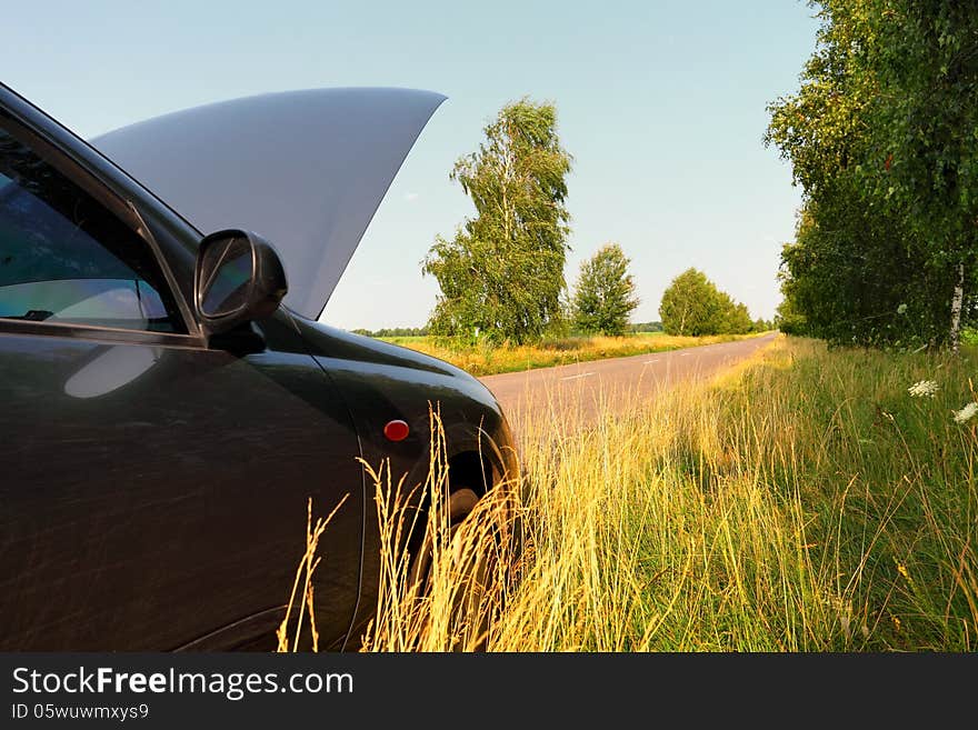 Car with opened hood, breakdown on rural road