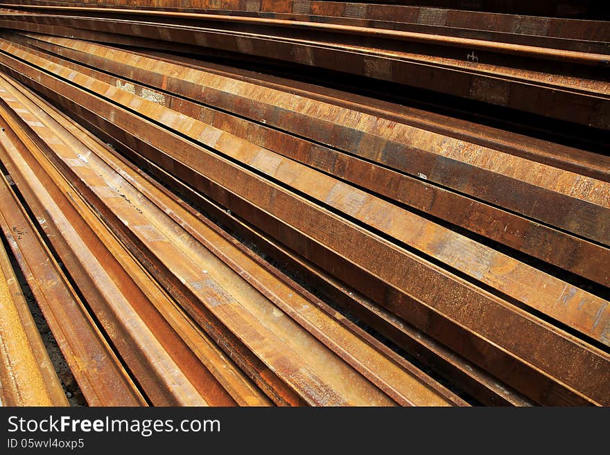 A pile rusty steel rails background. A pile rusty steel rails background