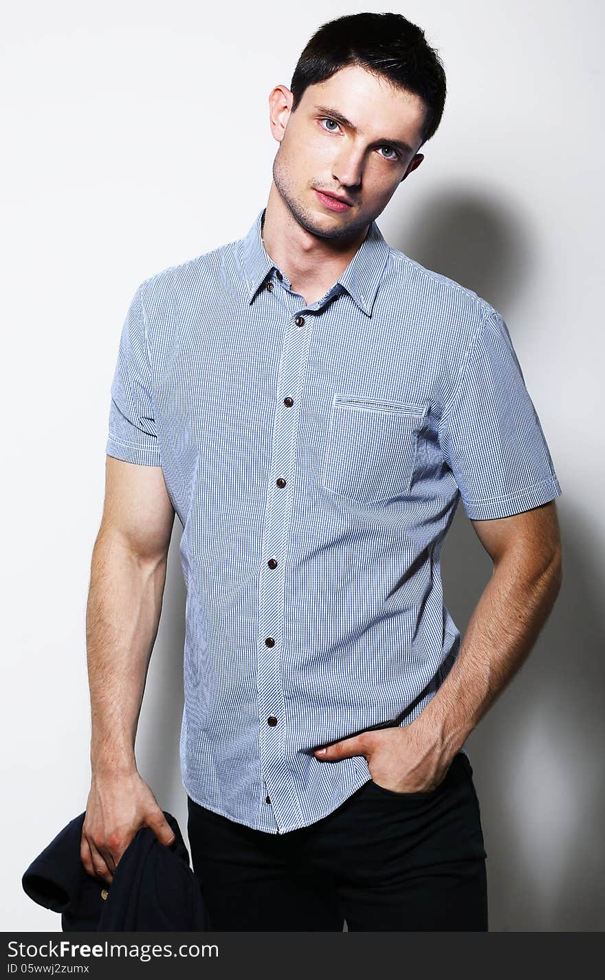 Fashionable Male in Blue Shirt standing in studio. Fashionable Male in Blue Shirt standing in studio