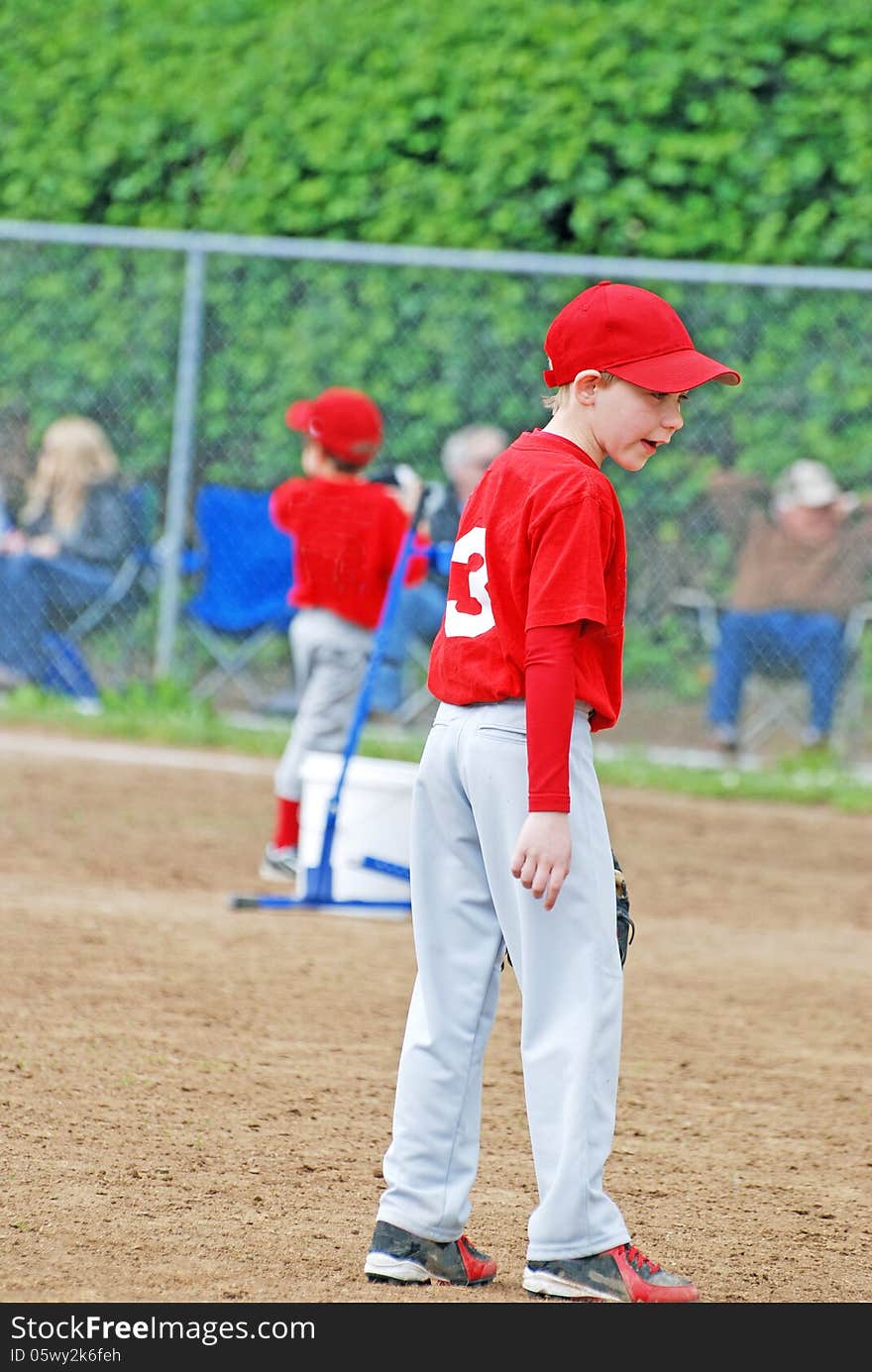 A young child playing Little League baseball and getting directions from his coach in a game played in June 2013 and Oregon. A young child playing Little League baseball and getting directions from his coach in a game played in June 2013 and Oregon.