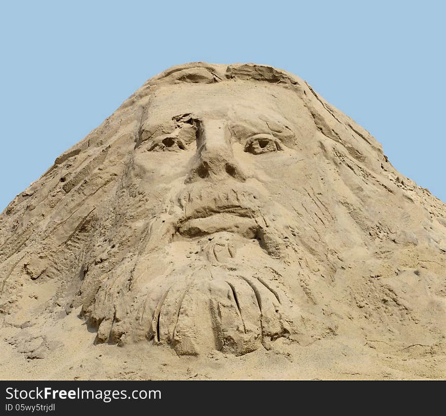 Face carved in a pile of sand against a blue sky, a depiction of Christ. Face carved in a pile of sand against a blue sky, a depiction of Christ.