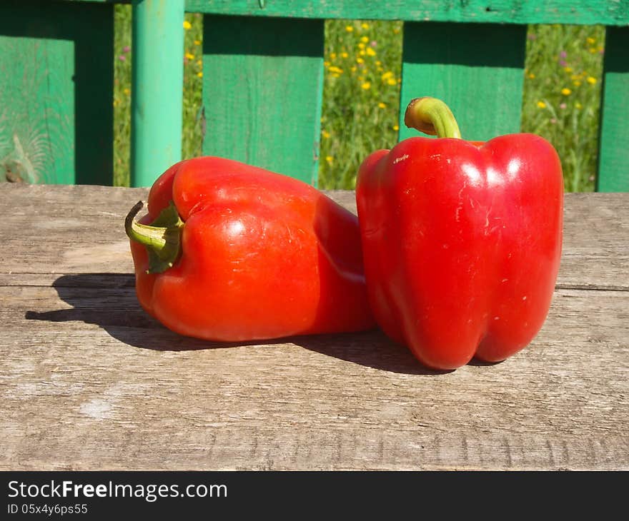 Two fresh red bell peppers on old wooden table. Two fresh red bell peppers on old wooden table.