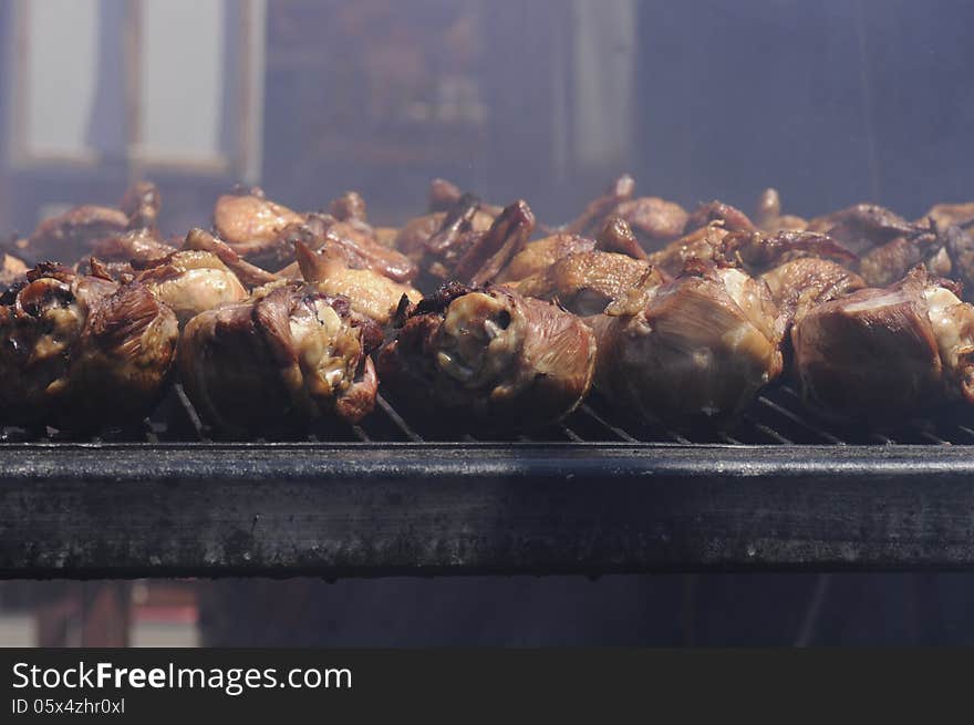 Close up of the bbq grill with a pile of turkey legs roasting and smoking to perfection. Close up of the bbq grill with a pile of turkey legs roasting and smoking to perfection