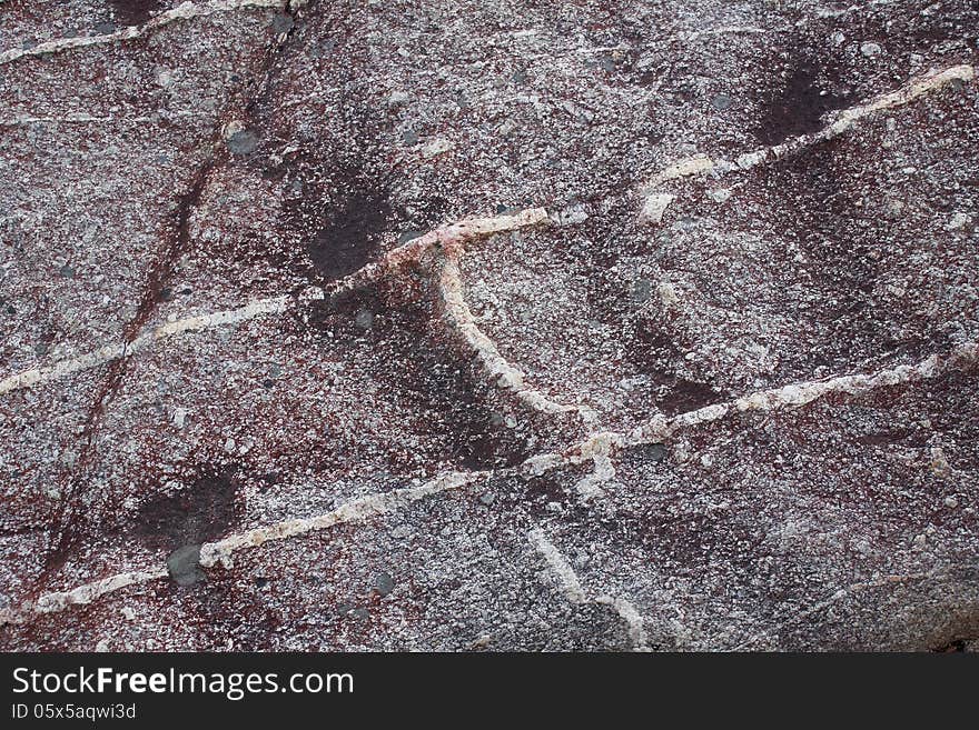 Surface of natural dark-red spotted stone with lines as background. Surface of natural dark-red spotted stone with lines as background