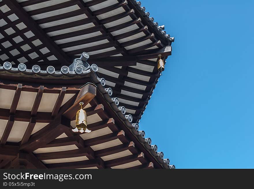 Corner View of Wooden Pagoda with Bells set against Blue Sky. Corner View of Wooden Pagoda with Bells set against Blue Sky