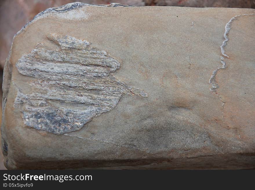 Stone with rough surface on pebble beach