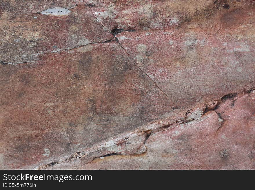 Surface of natural crack dark red stone (crimson quartzite porphyry) as background. Surface of natural crack dark red stone (crimson quartzite porphyry) as background