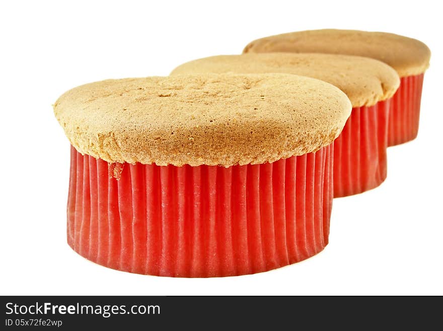 Row of three sponge cake in red paper cup on white background. Row of three sponge cake in red paper cup on white background