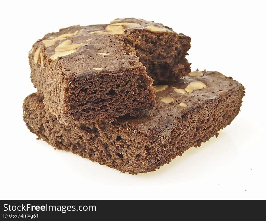 Cross stack of eating almonds brownies on full brownies cake on white background. Cross stack of eating almonds brownies on full brownies cake on white background