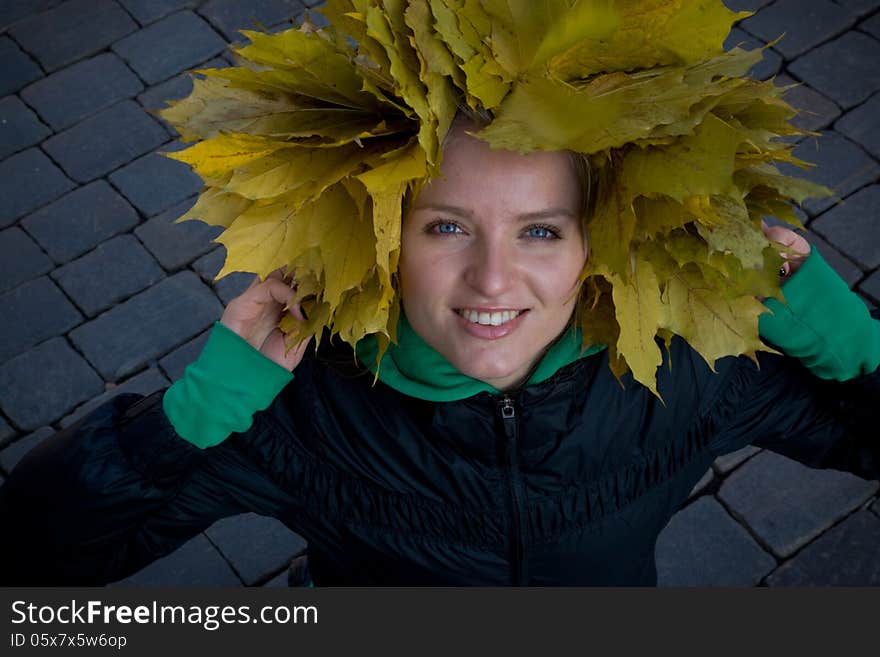 Photo of the girl in a headdress of yellow leaves. Photo of the girl in a headdress of yellow leaves