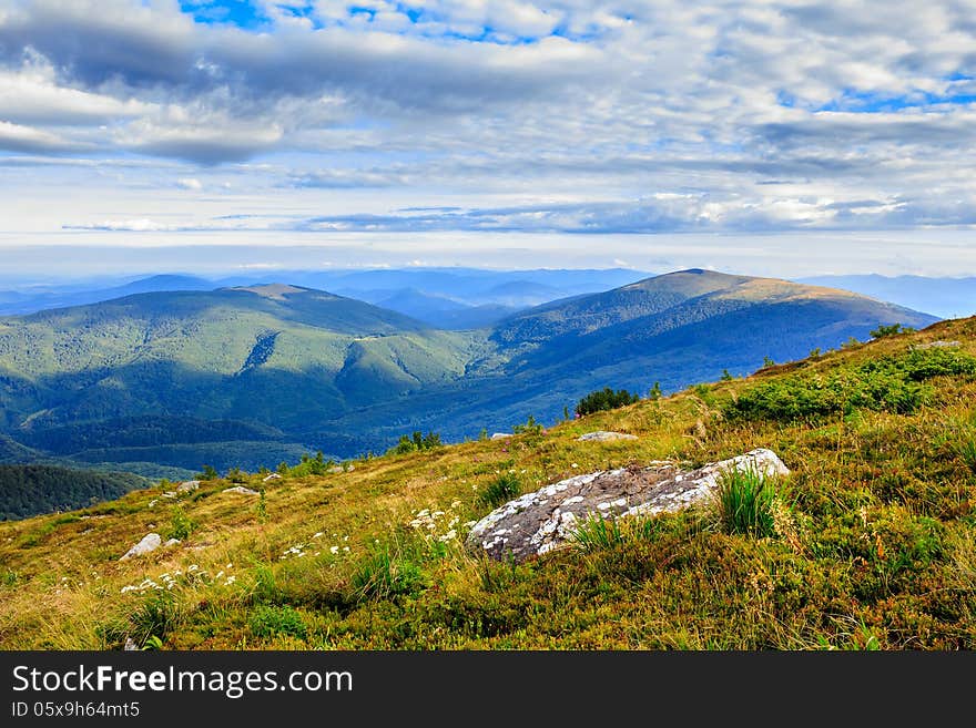 Mountain panorama with large rock on the hillside