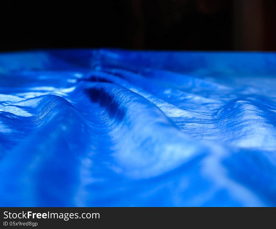 Detail of the cover of a billiard table with blue silk. Detail of the cover of a billiard table with blue silk.