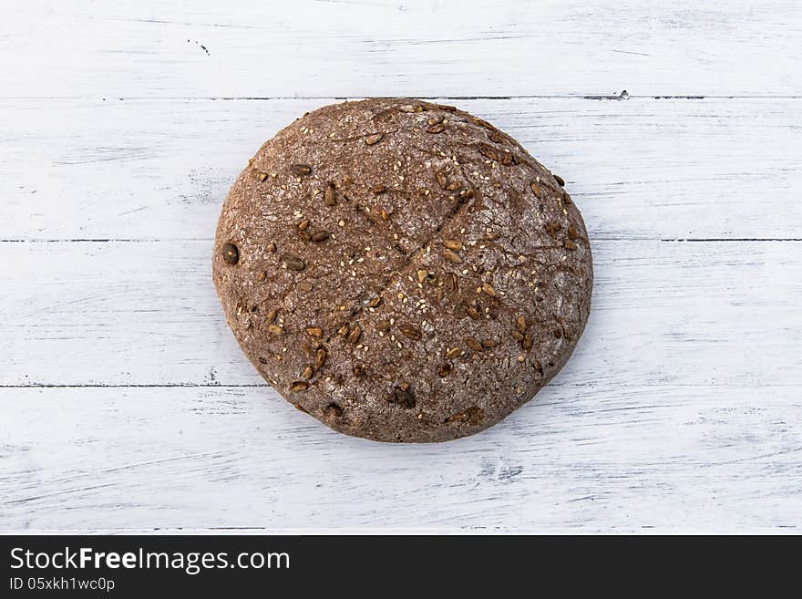 A loaf of wholemeal home baked bread on white board