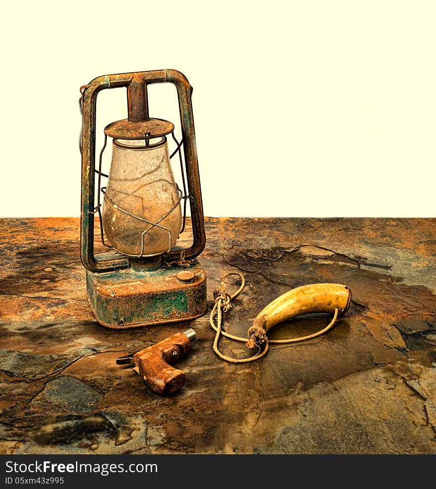 Antique pistol and powder horn with an old lantern on slate