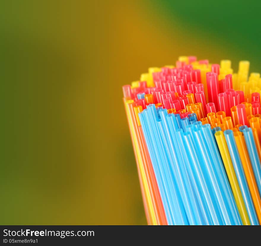 Green, yellow, blue, pink & red colored straws group. This represents concept of holiday, picnic, outing, and other travel concepts