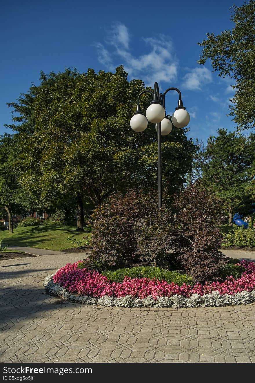 Lamppost in a park surrounded by trees and flowers