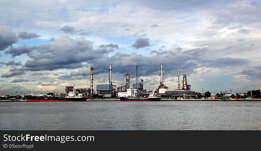 Oil refinery with thunderstorm background