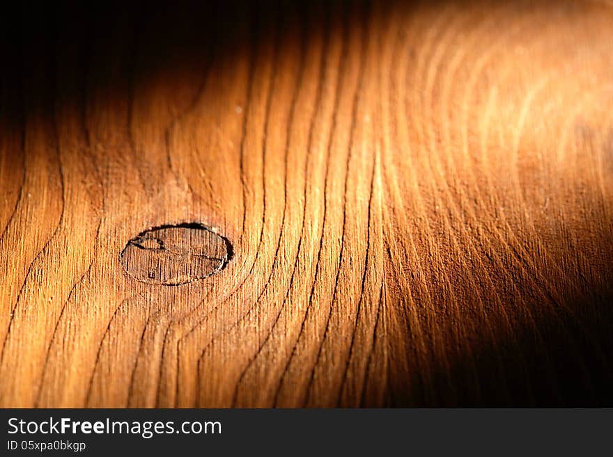 Nice wooden background with knot under beam of light