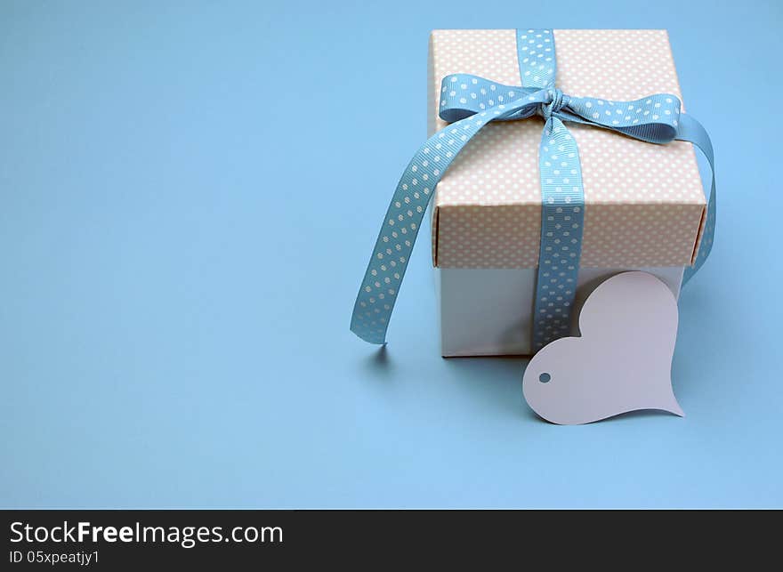 Blue and pink polka dot present with heart shape gift tag on aqua blue background for Christmas, Easter, Fathers Day or birthday present gift giving, with copy space for your text here. Blue and pink polka dot present with heart shape gift tag on aqua blue background for Christmas, Easter, Fathers Day or birthday present gift giving, with copy space for your text here.