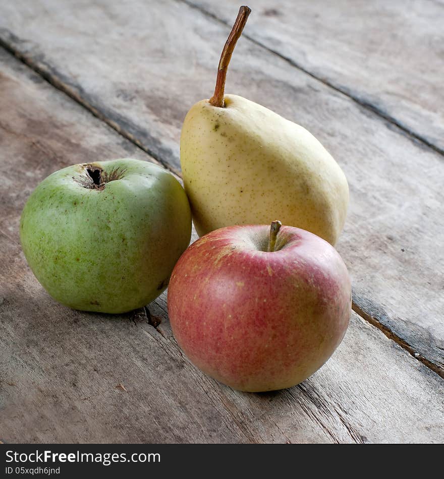 Fresh organic apples and pears on wooden table