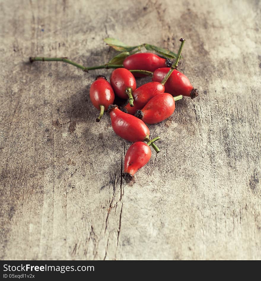 Rose hips on a wooden table, close up photo