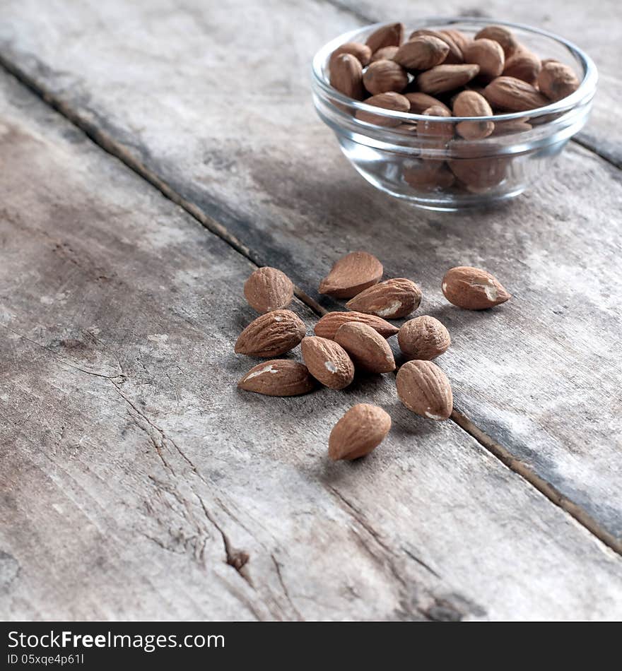 Roasted almonds on wooden table, food background