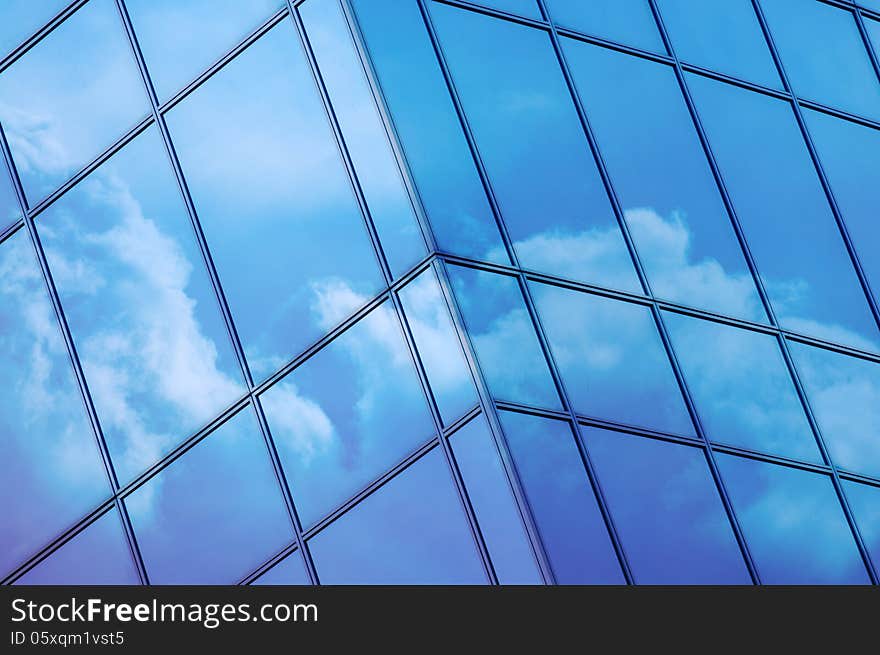 Clouds reflected in windows of modern office building