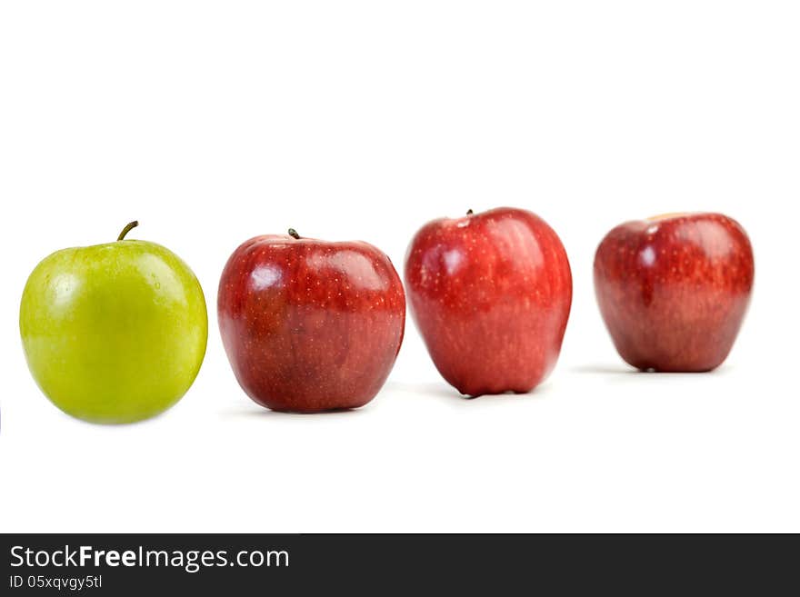 Ripe red apples and one green apple on white