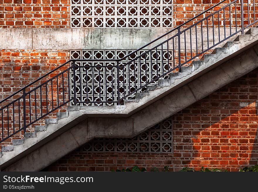 Outdoor staircase with a red brick wall