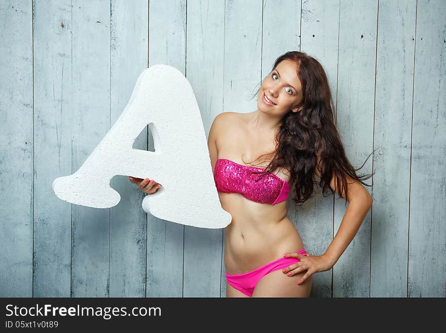 Beautiful girl in a bathing suit holds in hands letter. Beautiful girl in a bathing suit holds in hands letter