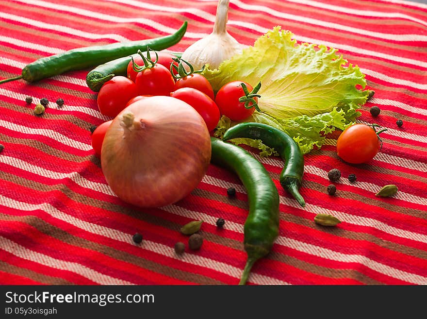 Assorted vegetables and spices on red textured fabric