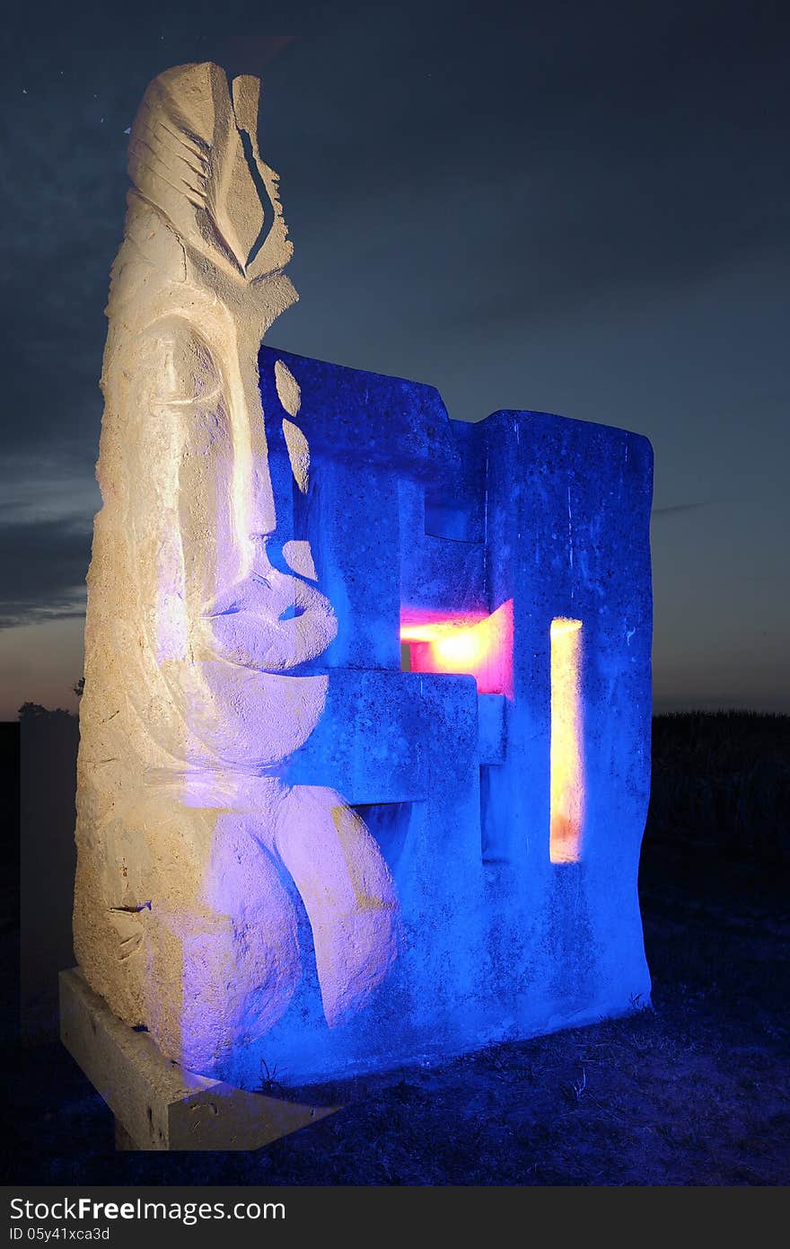 A composing of two stone sculptures, one realistic called Maya, the other one abstracted, called borderstone, this one was lit with blue light with colored openings. A composing of two stone sculptures, one realistic called Maya, the other one abstracted, called borderstone, this one was lit with blue light with colored openings