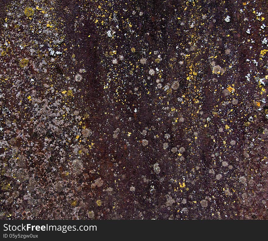 Texture of aged metal with brown, yellow and white speckles.
