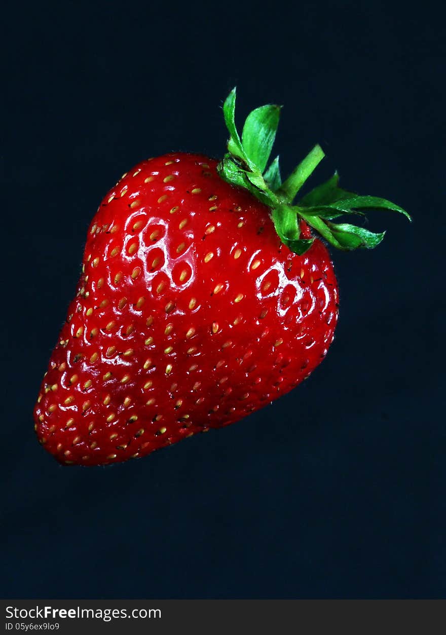 Single Ripe Strawberry Against Black Background. Single Ripe Strawberry Against Black Background