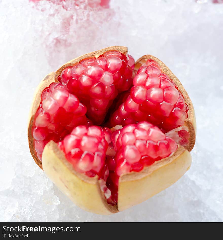 Red pomegranate fruit on ice