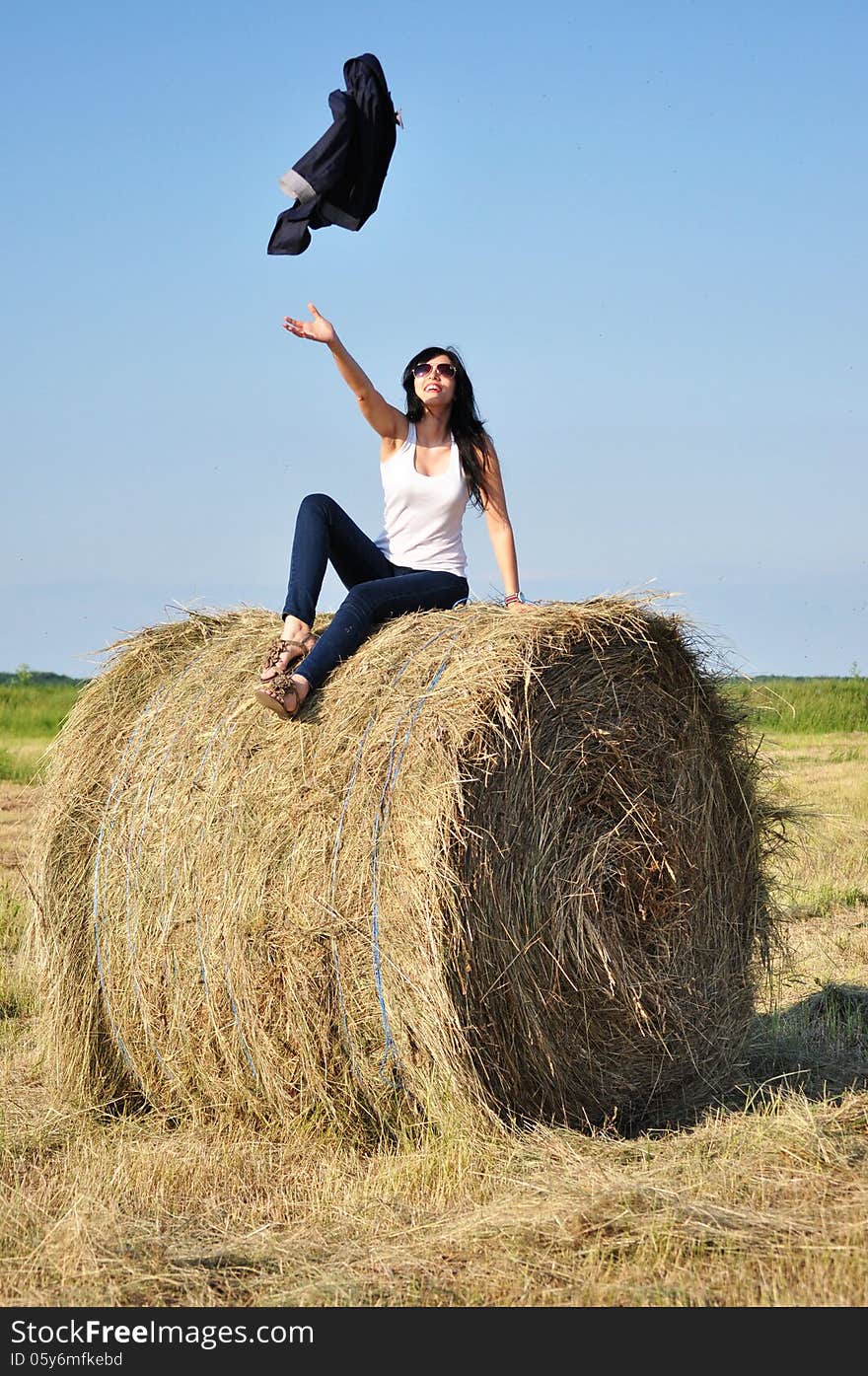 Beautiful girl sit on haystacks