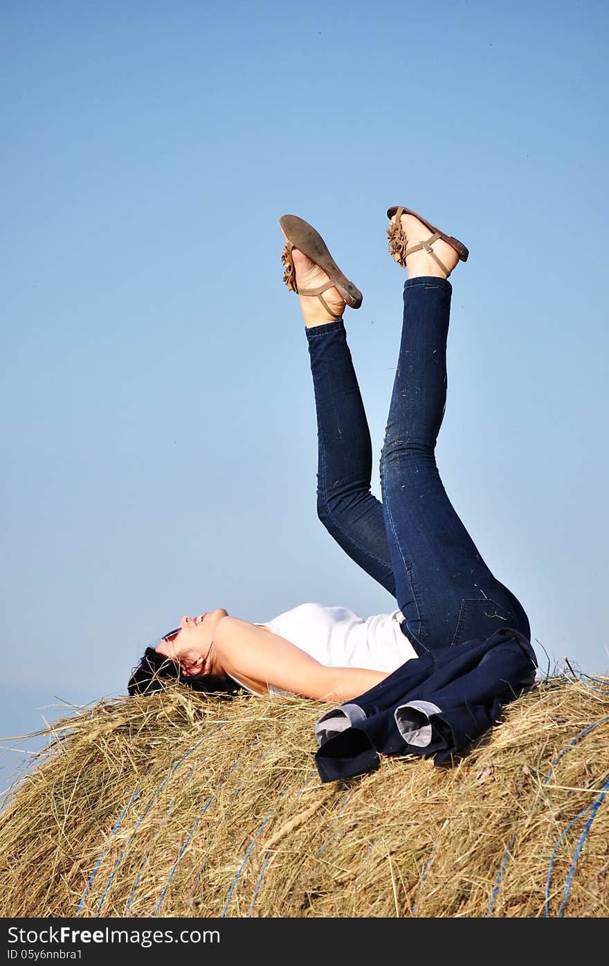 Beautiful girl sit on haystacks